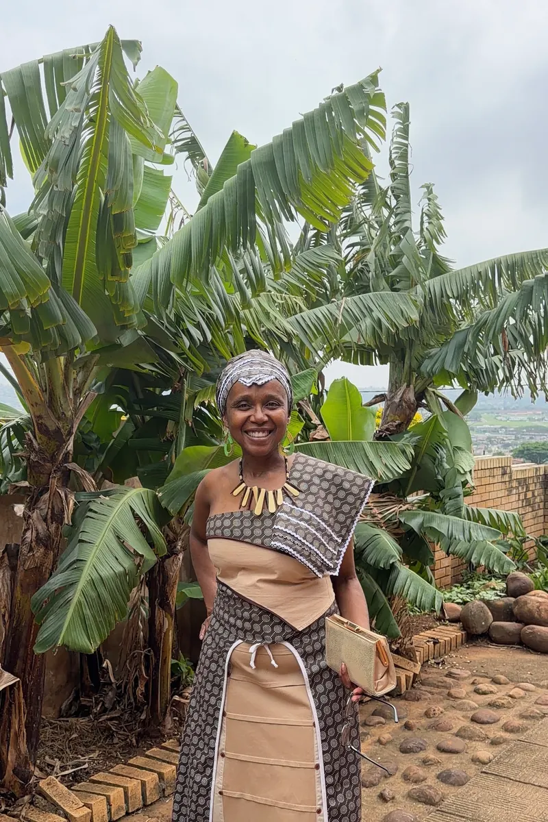 A wedding guest in traditional attire among banana palms, raw phone photo