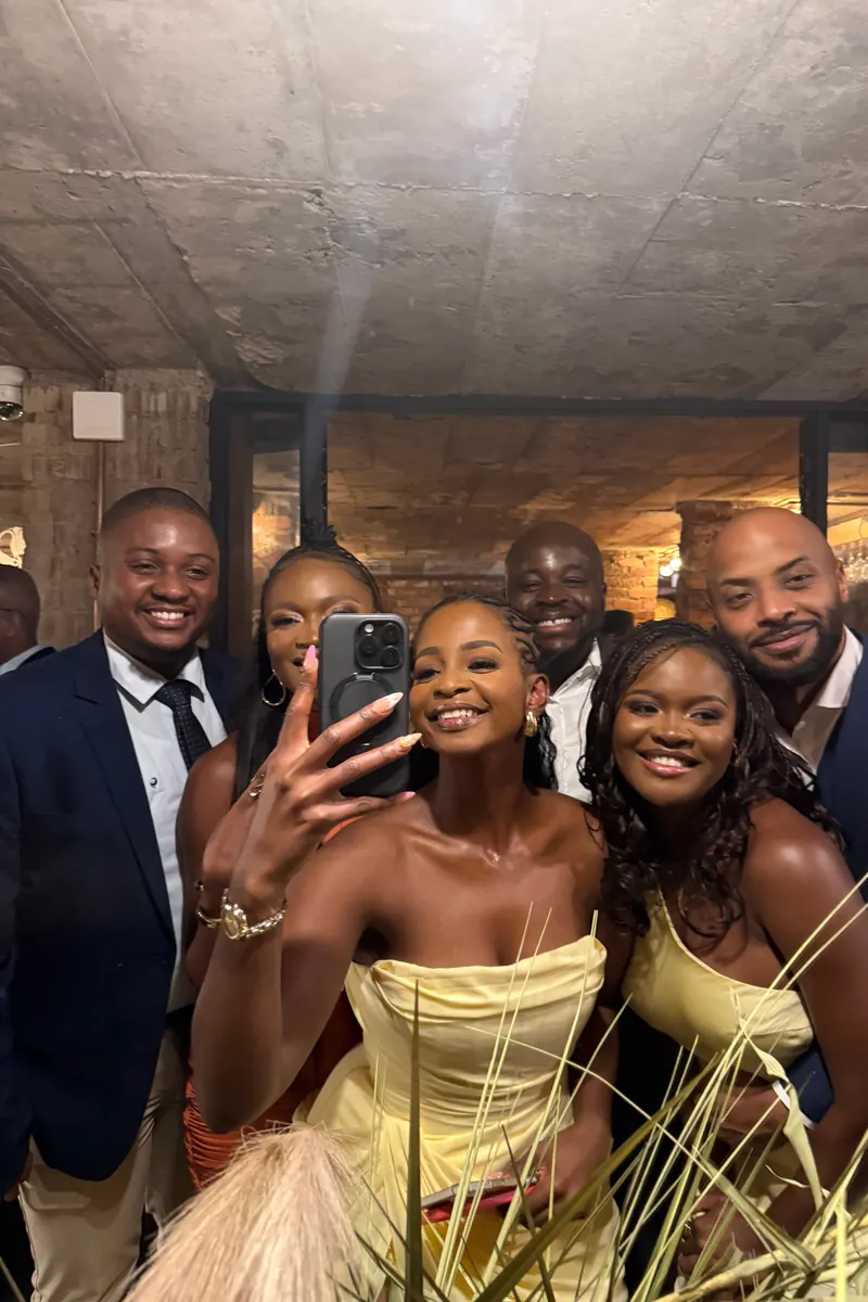 A group selfie of wedding guests at a KZN reception, raw phone photo
