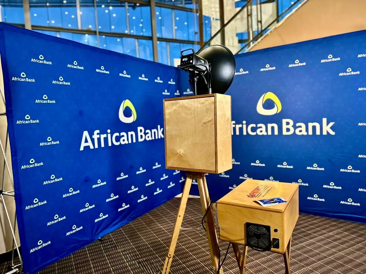 Retro DSLR photobooth and print kiosk in front of a branded step-and-repeat backdrop at a KZN corporate event