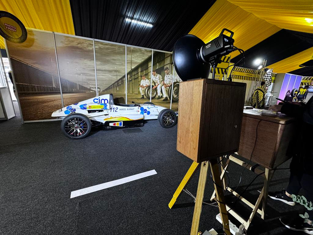 The retro photobooth set up at a corporate motorsport activation with a race car alongside