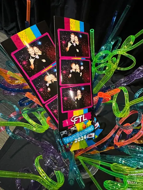 Printed photostrips lying among the glow props at an Alpine Heath event