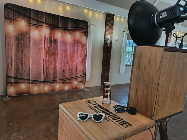 The retro photobooth against a lit timber backdrop at Bellwood, with the props table alongside