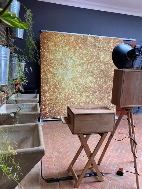 The retro photobooth set up against a gold backdrop in a Brahman Hills reception room