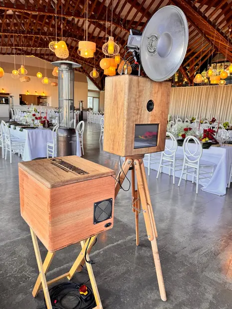 The photobooth beside set reception tables under warm lighting at Brahman Hills
