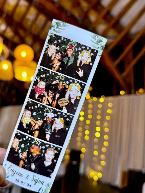 A printed photostrip held up against the fairy lights at a Brahman Hills wedding