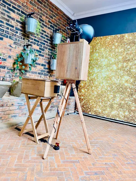 The photobooth and gold sequin backdrop against the brick wall at Brahman Hills