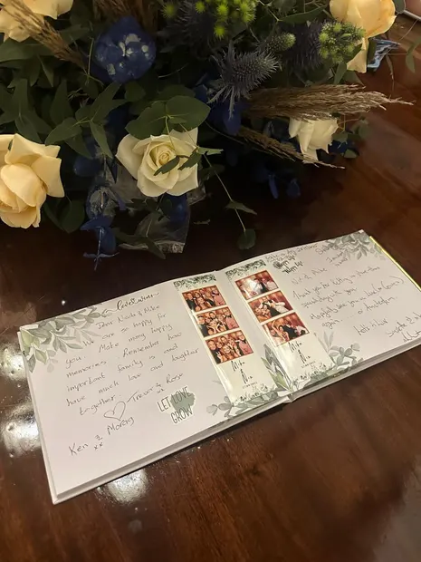 The photobooth guest book open beside the flowers at a Granny Mouse wedding