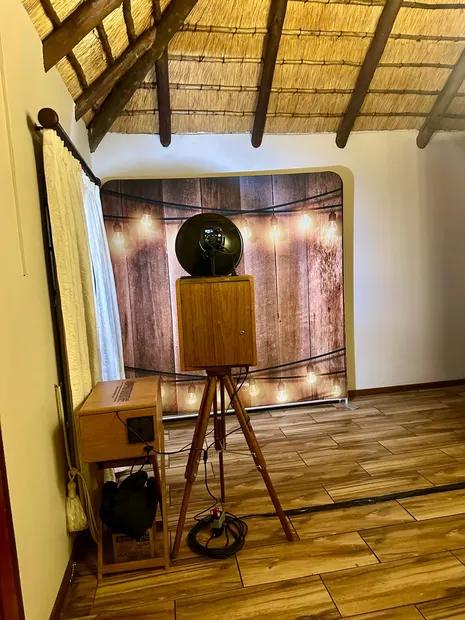 The retro photobooth and a lit timber backdrop under the thatch at Granny Mouse Country House