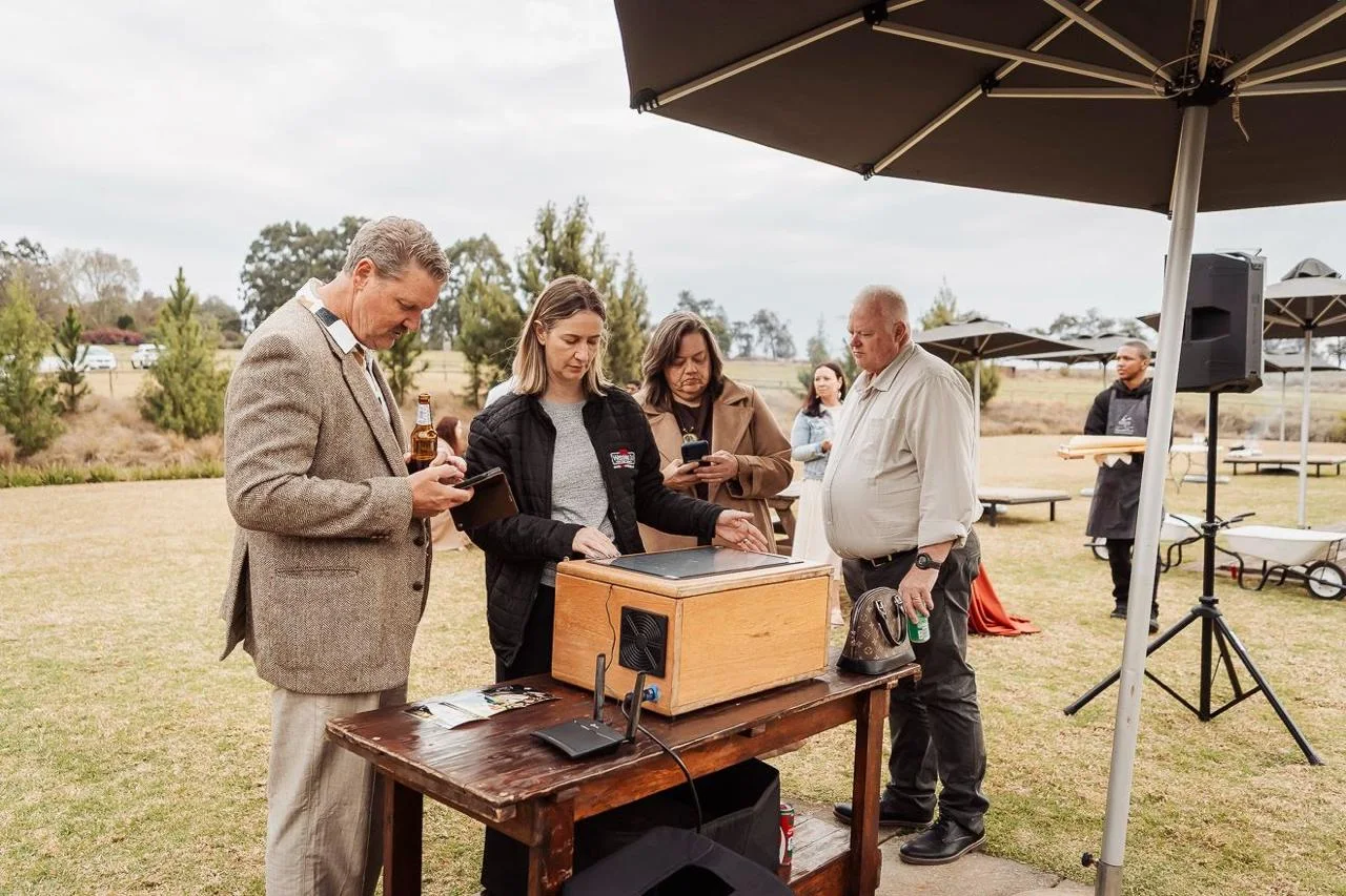 Guests printing their photographs at the instant printing kiosk on the lawn at Haycroft Farm, Curry&rsquo;s Post