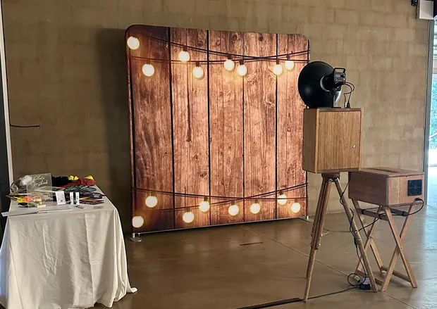 The lit timber backdrop and retro photobooth beside the props table at Haycroft Farm