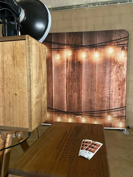 The retro photobooth facing the lit timber backdrop with prints laid out at Haycroft Farm