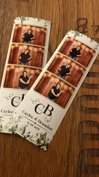 Two printed photostrips from a Haycroft Farm wedding lying on a timber table