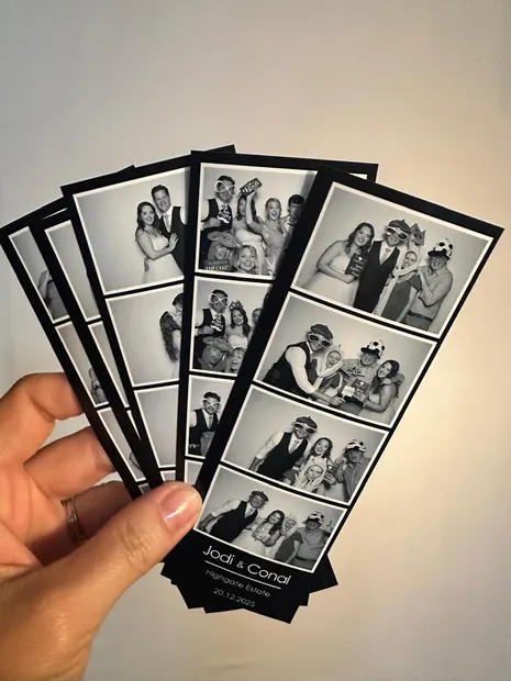 Black and white photostrips branded Highgate Estate held up at a wedding