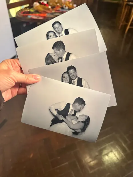 Black and white postcard prints from a Highgate Wine Estate wedding held up
