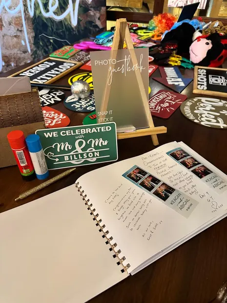 The photobooth guest book with photostrips pasted in, beside the props table at Highgate