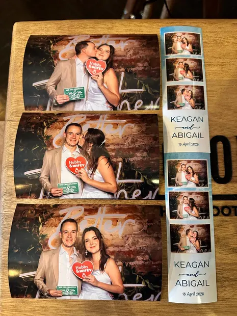 Postcard prints and a photostrip laid out on a wine barrel at a Highgate wedding