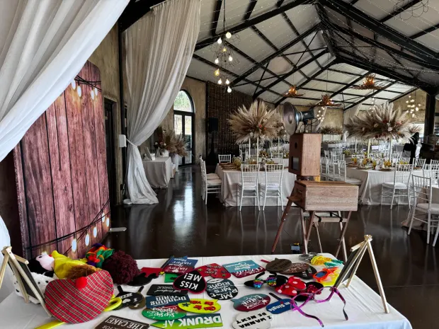 The photobooth, props table and set tables in the reception venue at Netherwood Farm