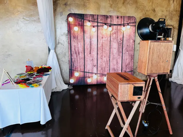 The photobooth and lit timber backdrop against the white draping at Netherwood Farm