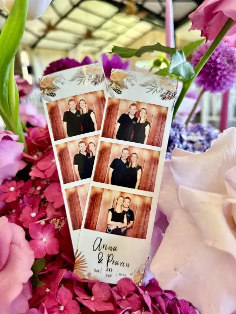 A photostrip tucked into a pink floral arrangement at a Netherwood Farm wedding