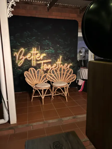 The Better Together neon backdrop and rattan peacock chairs on the veranda at Providence