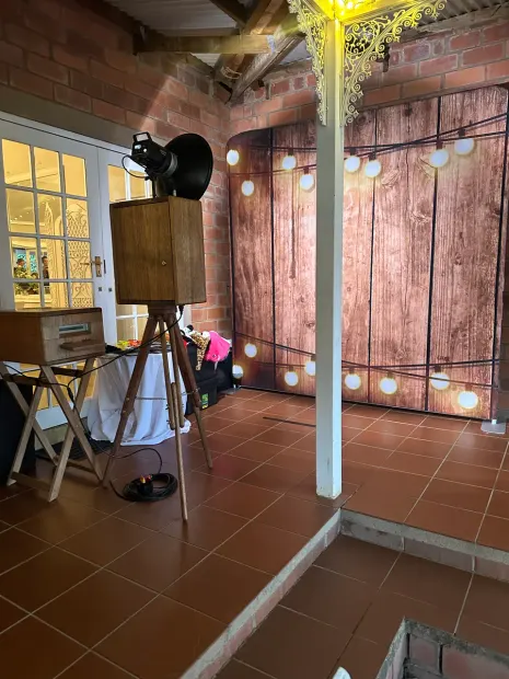 The photobooth and lit timber backdrop under festoon lights on the brick veranda at Providence