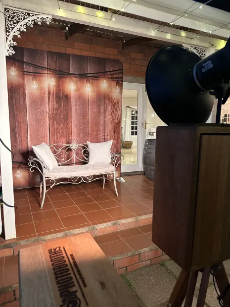 The photobooth facing a lit timber backdrop and bench on the veranda at Providence
