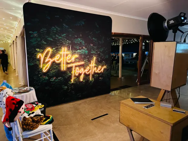 The props table and Better Together neon backdrop beside the photobooth at Providence