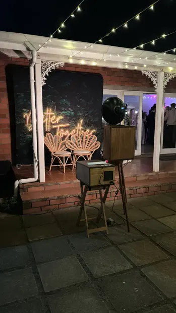 The photobooth and neon backdrop on the veranda at Providence under festoon lights