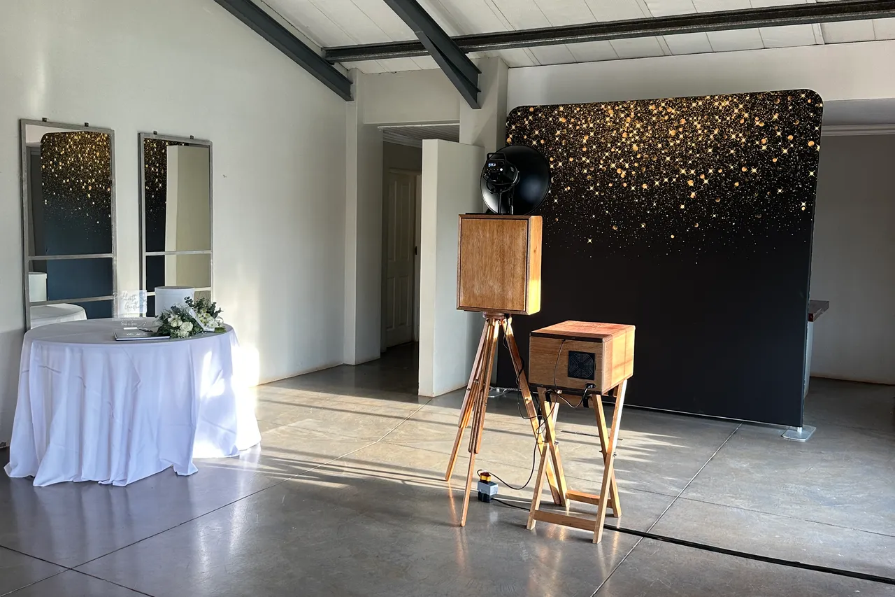 The retro photobooth and a gold-sparkle backdrop in the reception hall at Sweet Home, Eston