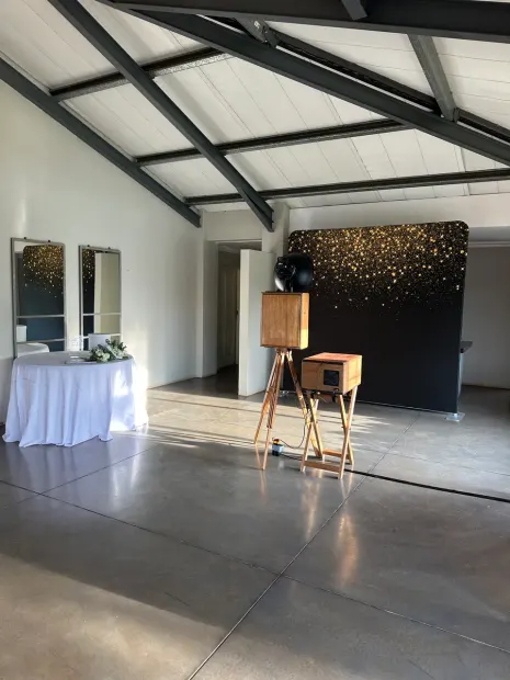 The retro photobooth and a gold-sparkle backdrop in the reception hall at Sweet Home