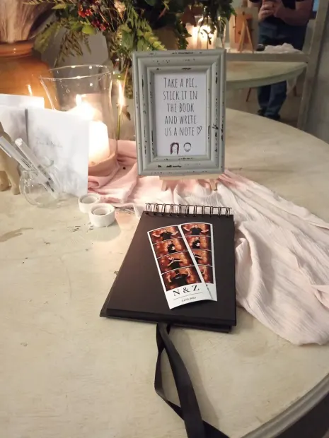 A photostrip stuck into the guest book beside the sign asking guests to write a note at Sweet Home