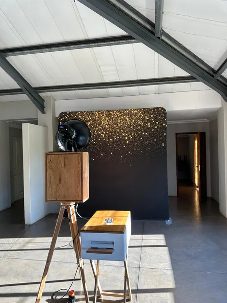 The retro photobooth against the gold confetti backdrop in the hall at Sweet Home
