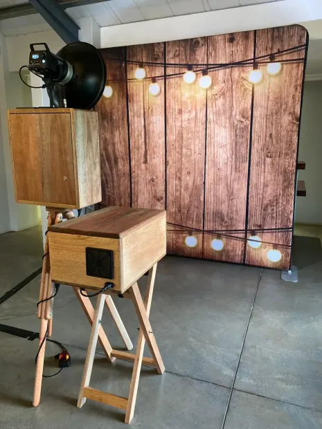 The retro photobooth facing the lit timber backdrop at Sweet Home