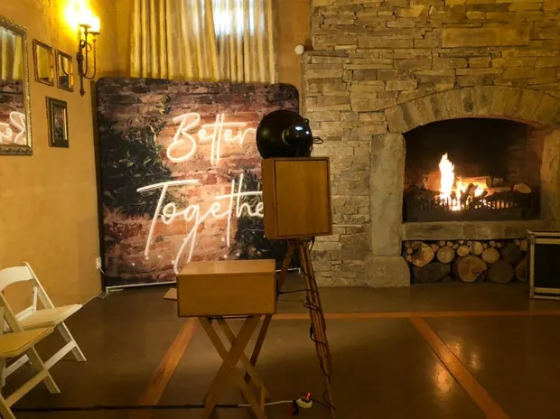 The photobooth beside the stone fireplace and a Better Together neon sign at The Gallery
