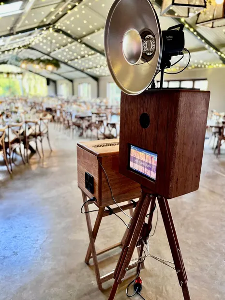 The photobooth inside the barn at The Glades with the tables set under fairy lights