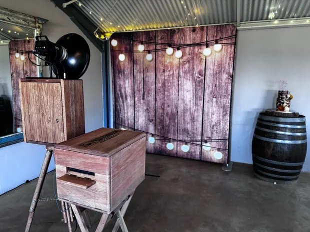 The photobooth against the festoon-lit timber backdrop in the barn at The Glades