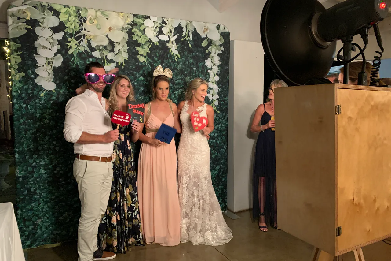 Wedding guests posing with props in front of the foliage wall at The Groves in the KZN Midlands