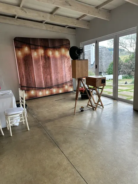 The photobooth and a lit timber backdrop beside the doors to the lawn at The Groves