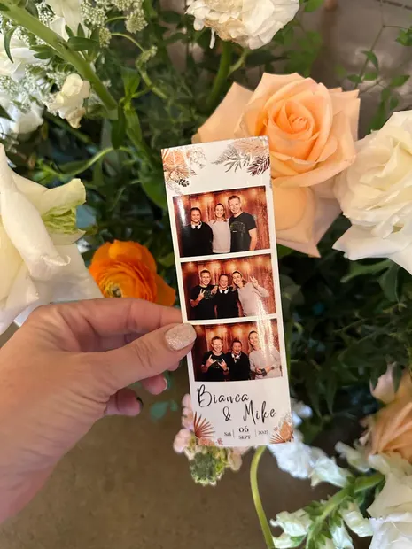 A photostrip held up against the wedding flowers at The Groves